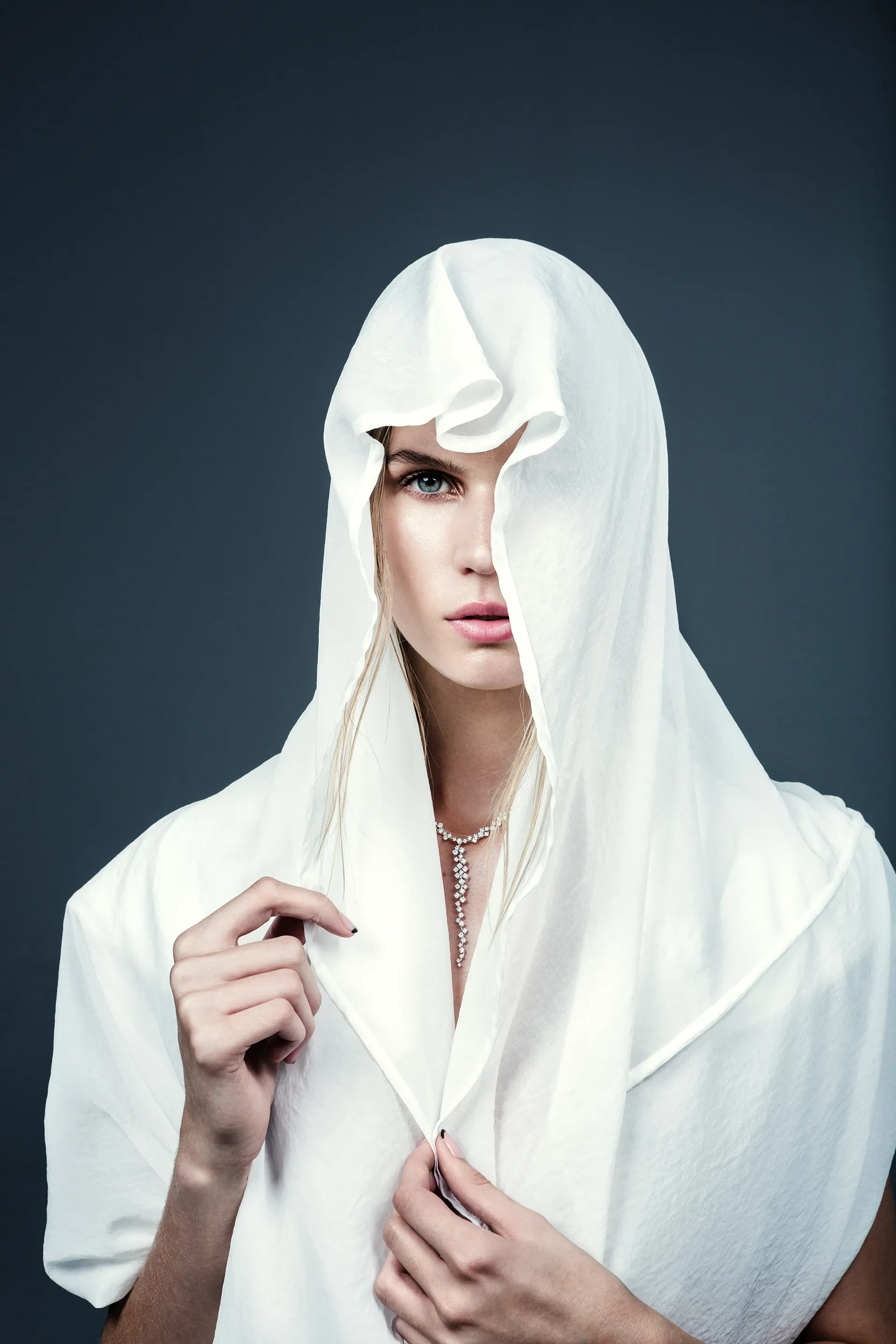Model wearing a white hood in a fashion portrait